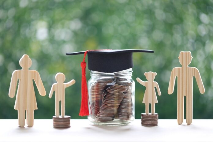 Graduation hat on glass bottle with model family and stack of co