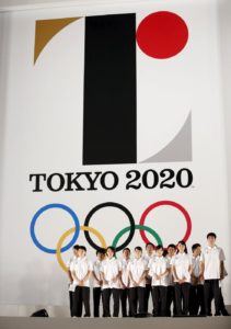 Athletes stand in front of Tokyo 2020 Olympic games emblem during an unveiling event at Tokyo Metropolitan Government Building in Tokyo July 24, 2015. The Tokyo Organising Committee of the Olympic and Paralympic Games unveiled the emblems on Friday, to mark the exactly five years before the 2020 Summer Games open in Tokyo. REUTERS/Issei Kato